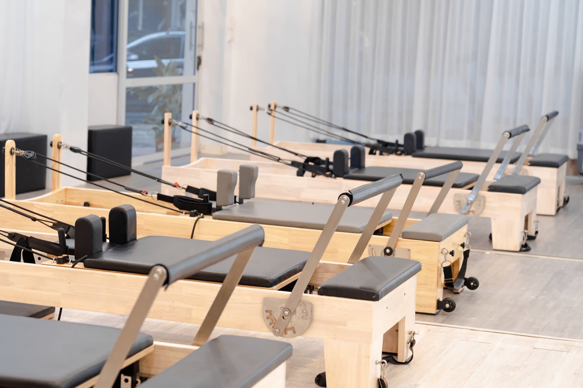 Pilates reformers arranged in a light, airy studio