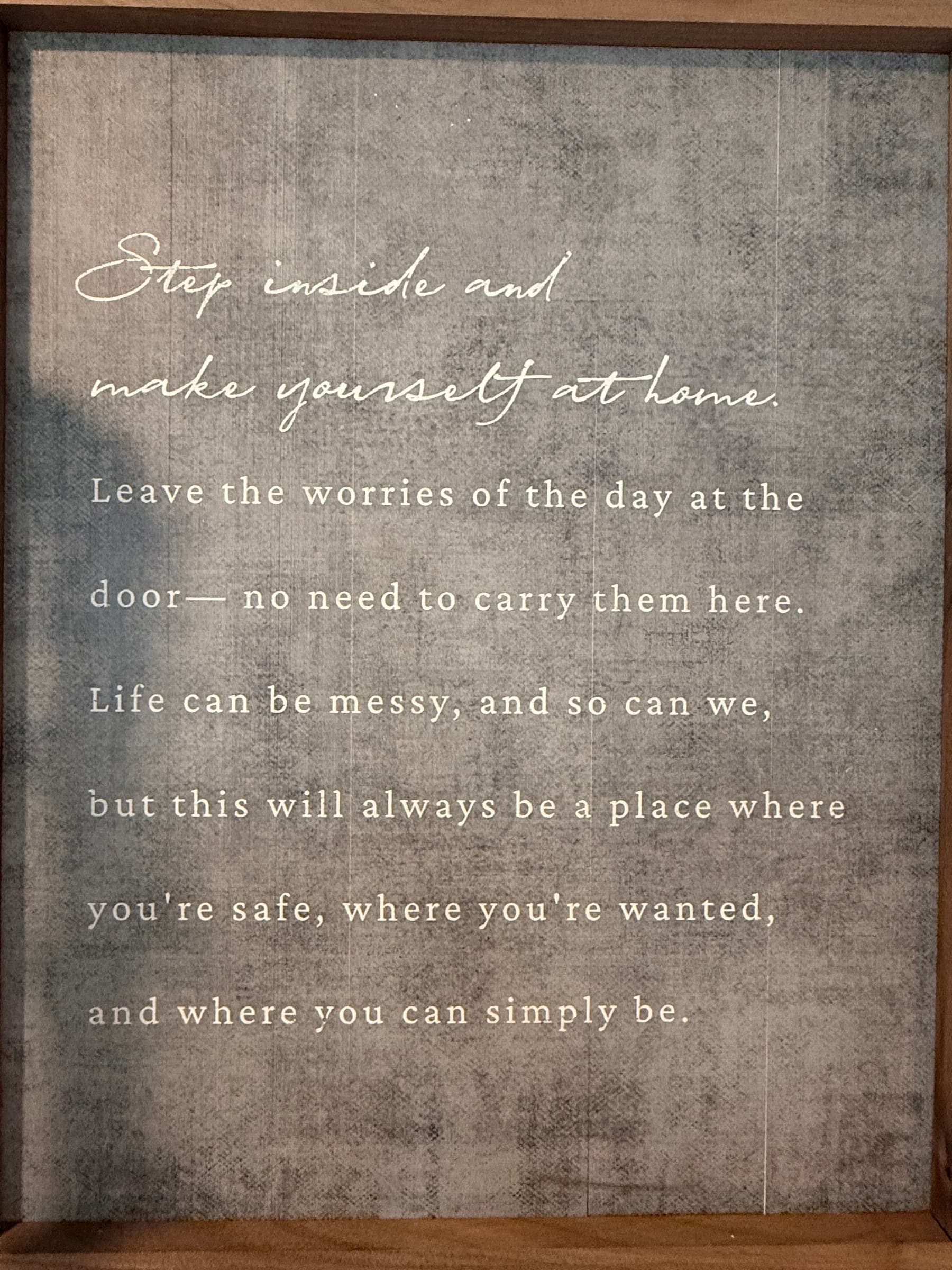 Framed studio sign reading "Step inside and make yourself at home" at Rooted in Strength Pilates